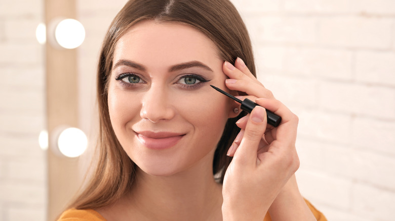 Woman applying eyeliner