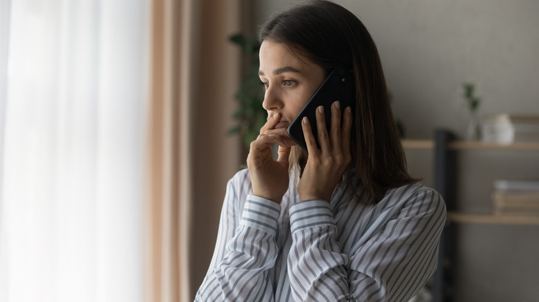 Woman looks serious while talking on phone