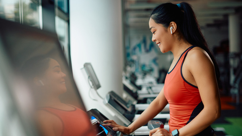 Woman with earbuds at gym