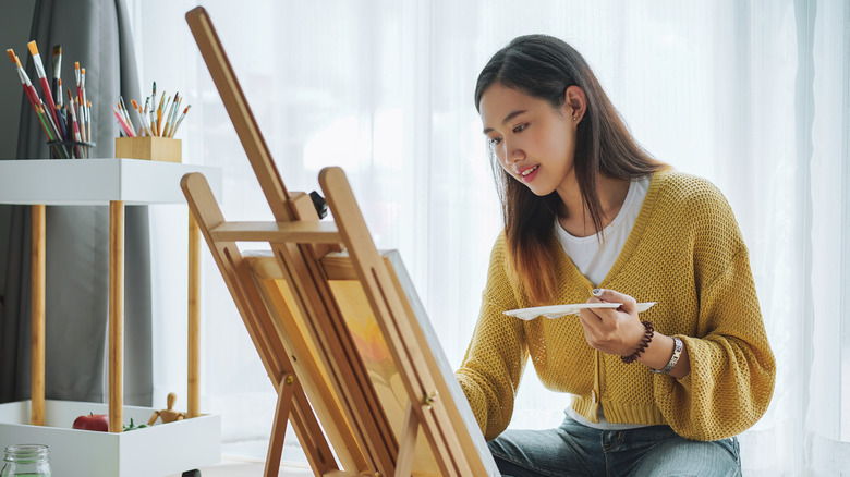 Woman painting on canvas