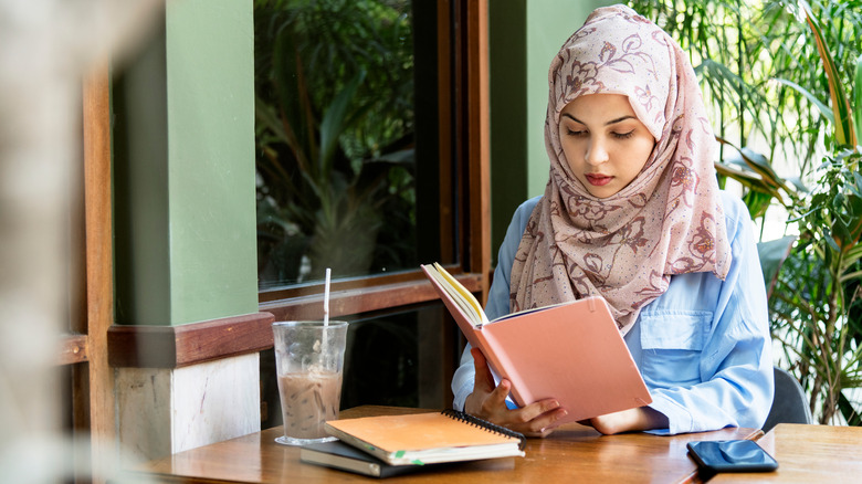 Hijabi woman reading a book