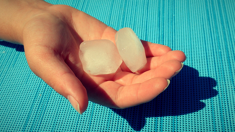 Hand holding two ice cubes