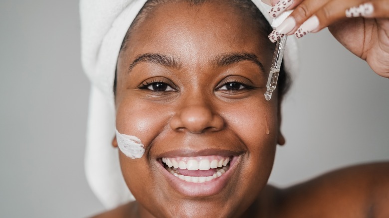 woman applying skincare with dropper