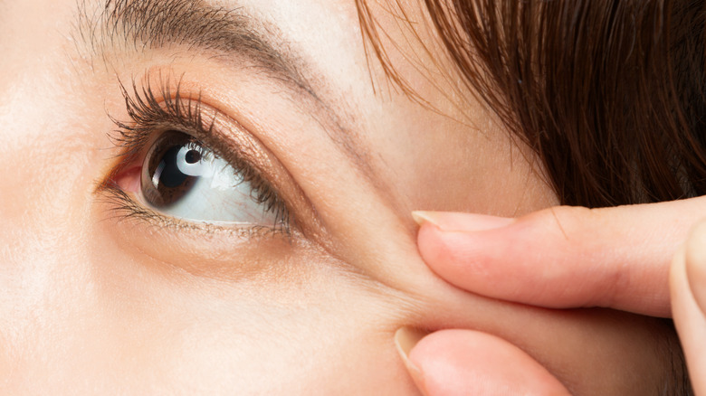 woman pinching eyebrow