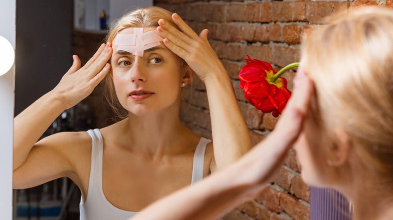 woman with tape on her forehead