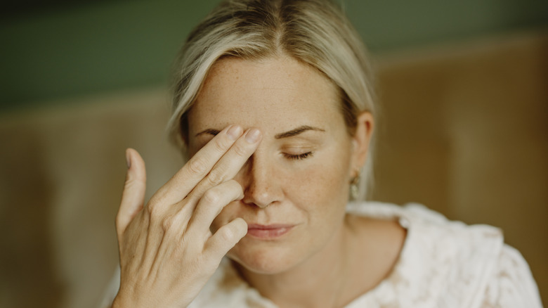 woman tapping face with fingers