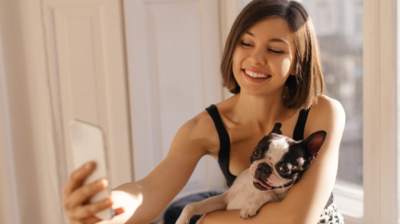 Woman taking selfie with her dog