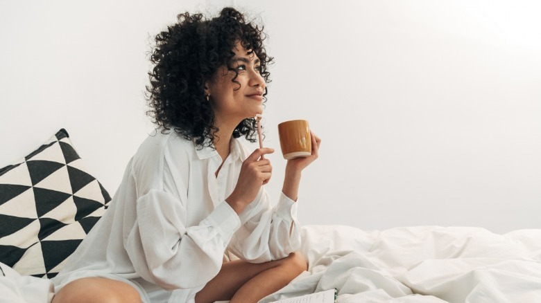 Woman sitting in bed thinking