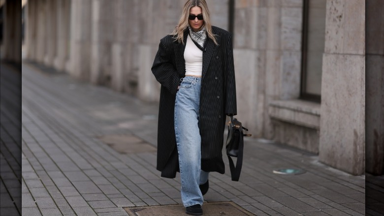 Woman wearing pinstriped coat, jeans