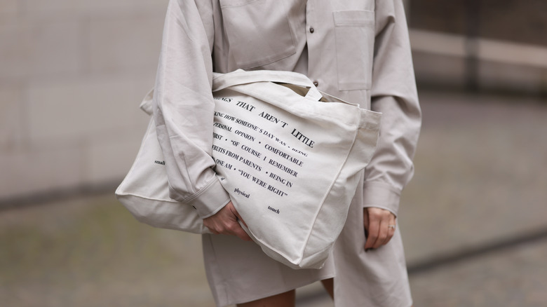 woman carrying a white canvas bag