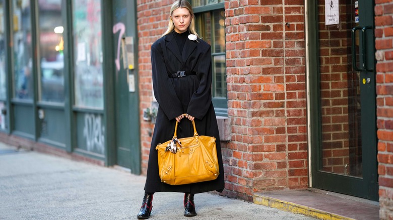 woman holding a large yellow bag