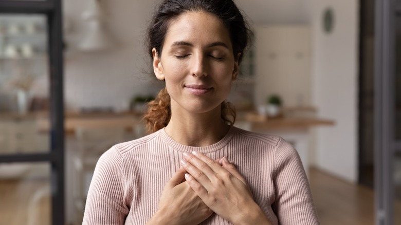 Woman with hands over heart