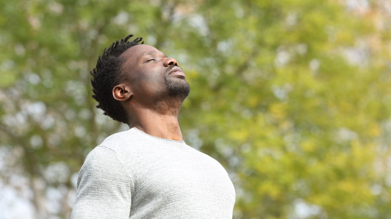 Man standing outside deep breathing