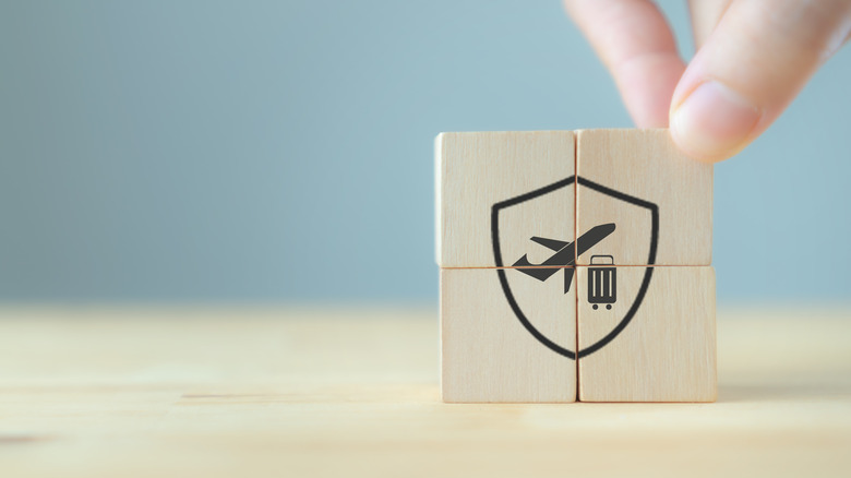 Wooden blocks showing icons about travel insurance