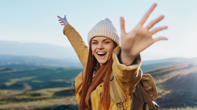 Happy woman hiking hilly vista