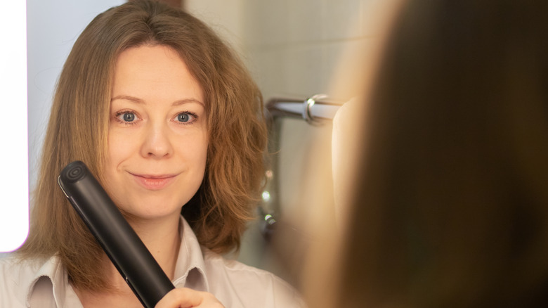 Woman straightening curtain bangs