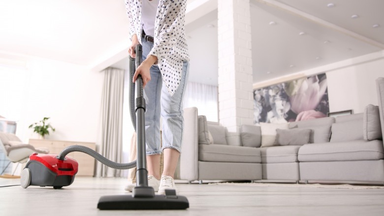 Woman vacuuming hardwood floor