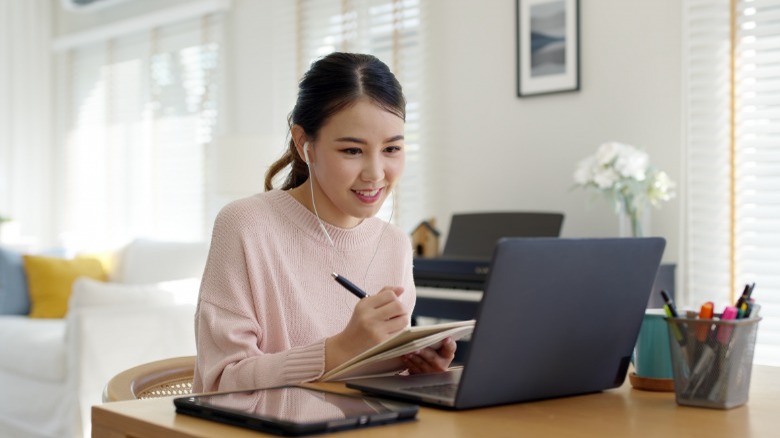 Woman taking notes from computer