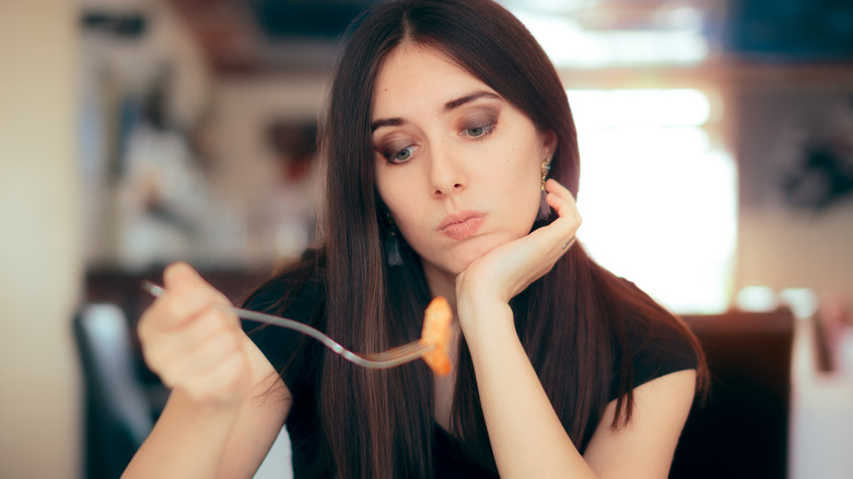 woman holding fork with food 