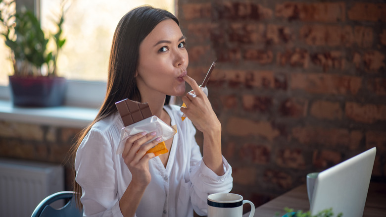 woman working eating chocolate