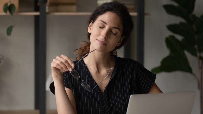 woman eyes closed at desk