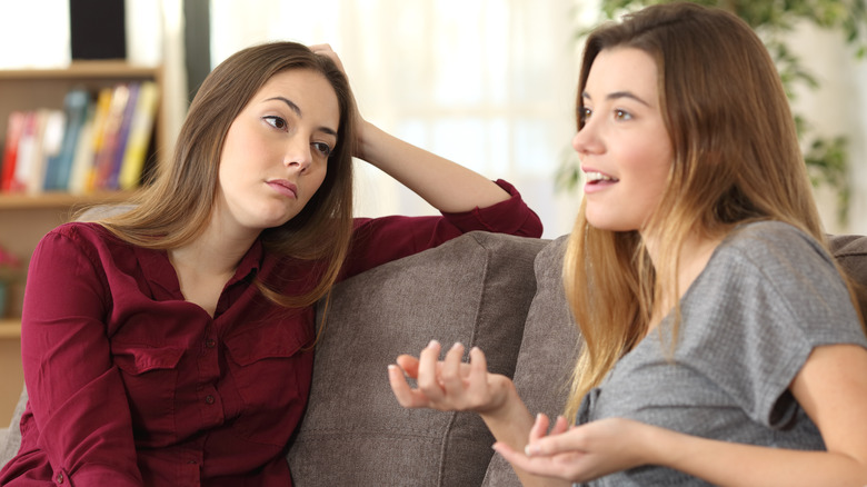 Woman looking bored talking to friend