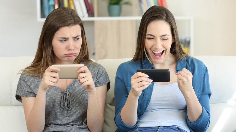 Woman jealous of friend laughing on phone