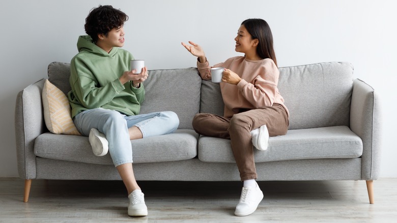Woman and man converse on sofa