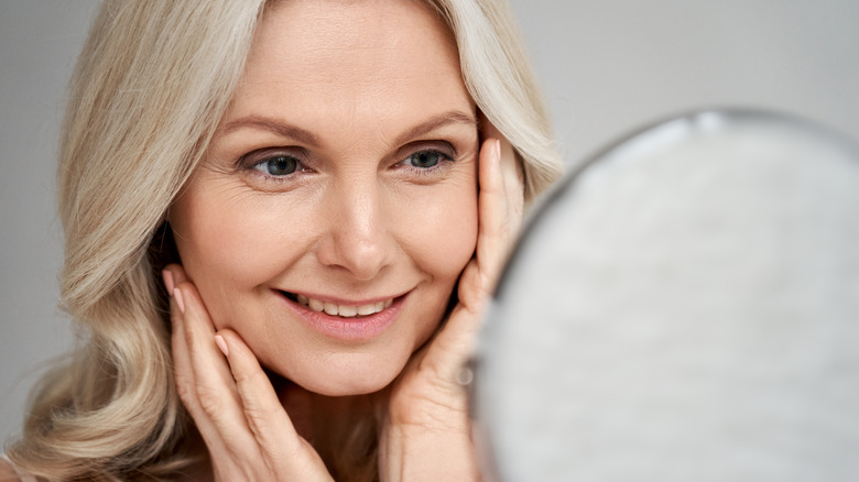 smiling woman looking in mirror