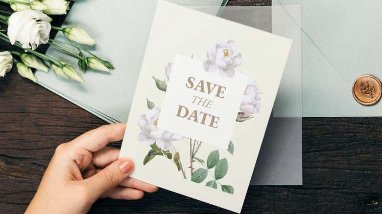 Hand holding save the date