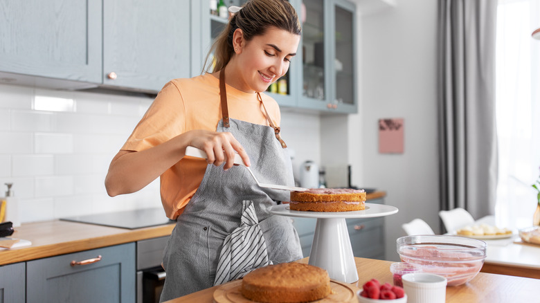 Woman frosts layer cake