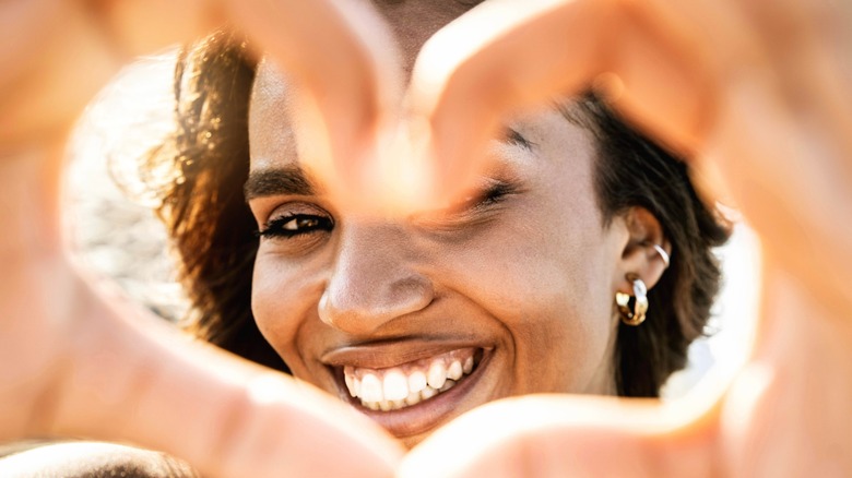 Woman makes hand hearts