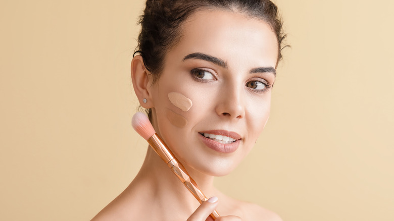 Woman applying bronzer to her face