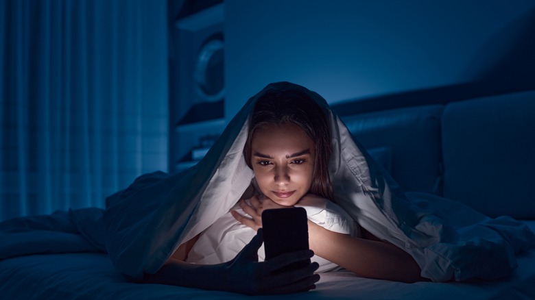 woman using phone before bed
