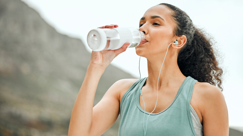 Active woman drinking water