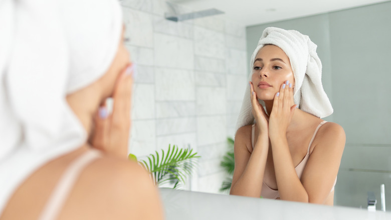 Woman doing skincare in mirror