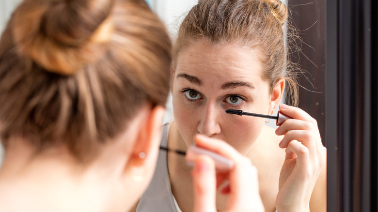 Woman applying mascara