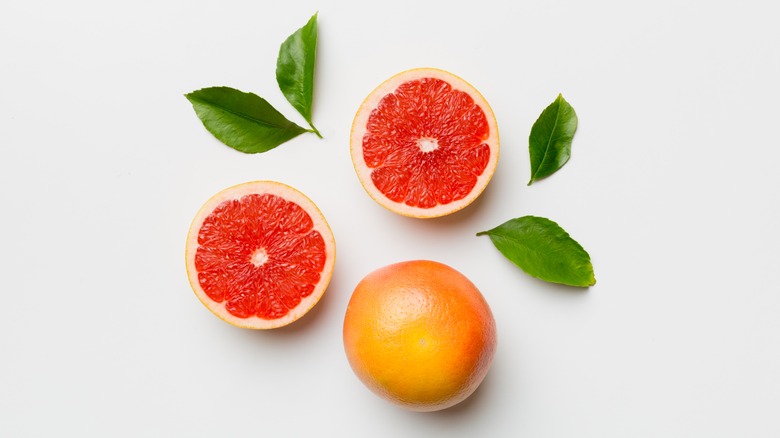 overhead shot of grapefruits and leaves on white background