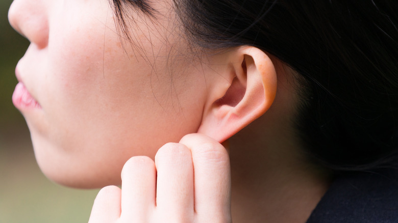 A woman massaging her earlobes