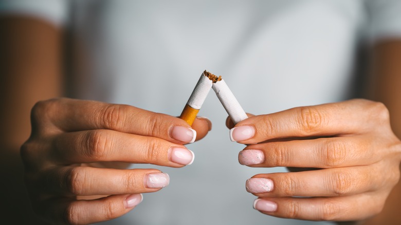 A woman breaking a cigarette 