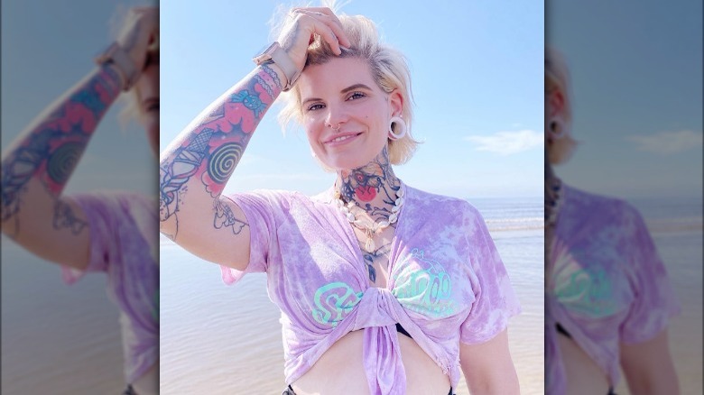 Woman with tattoos wearing purple