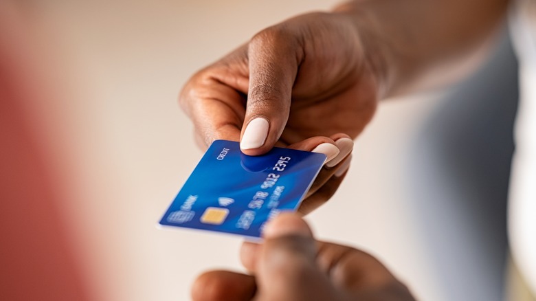 person handing credit card