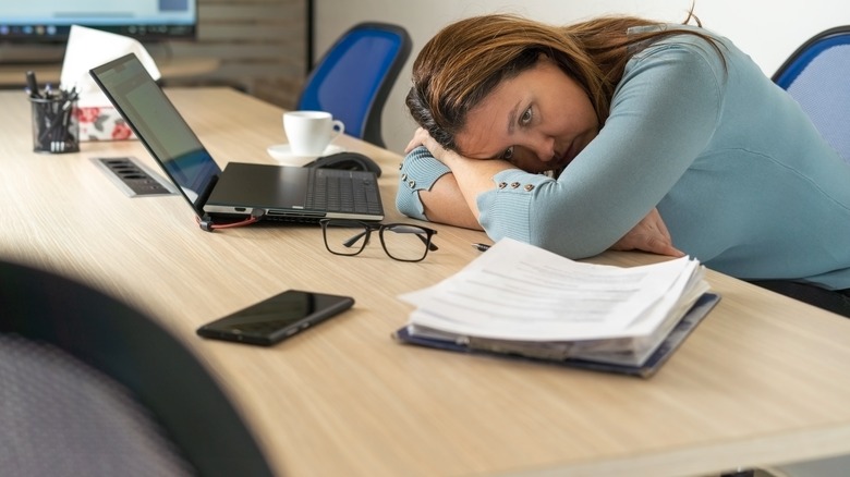 Tired woman resting on desk