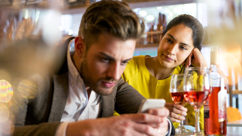 woman watching man texting