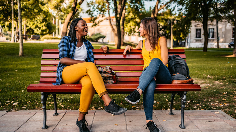 Friends talking on park bench