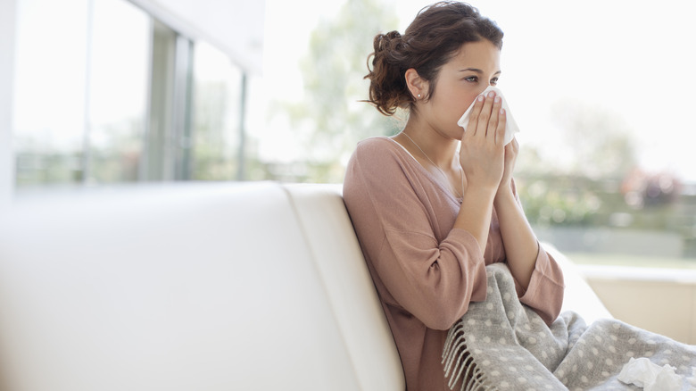 Sick woman blowing nose 