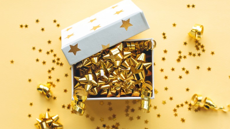 Gift box with gold bows and confetti