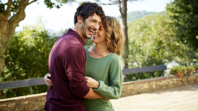 Man and woman hugging and laughing outdoors