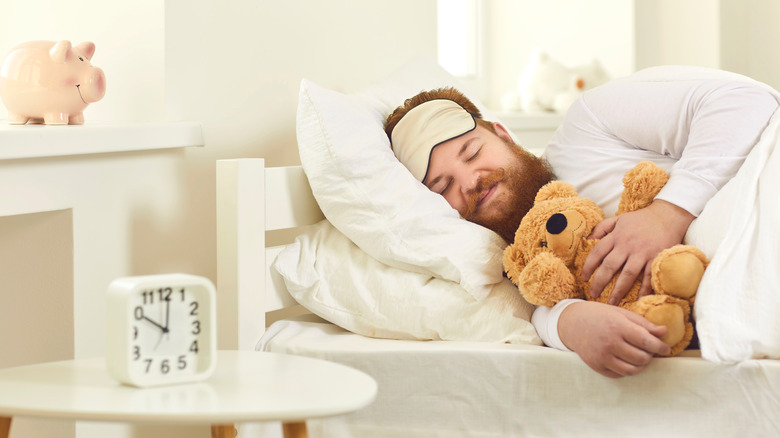 man sleeping with teddy