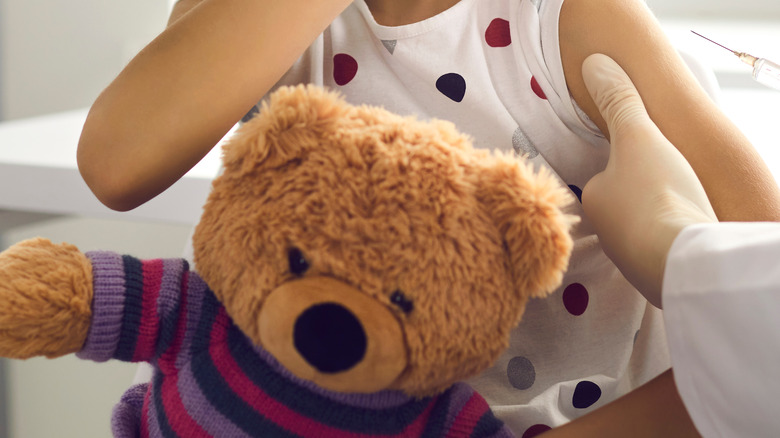 girl holding teddy bear doctor